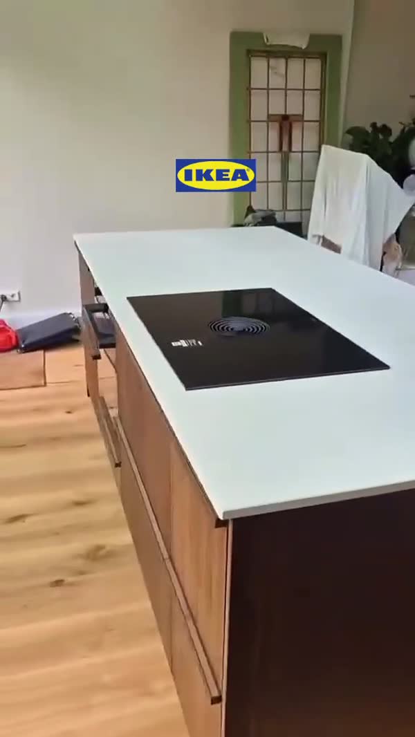 Kookeiland met donkere houten fronten en een wit werkblad met inductiekookplaat
