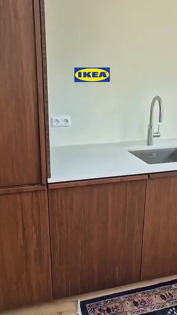 Spoelbak in een wit werkblad boven donkere houten keukenfronten