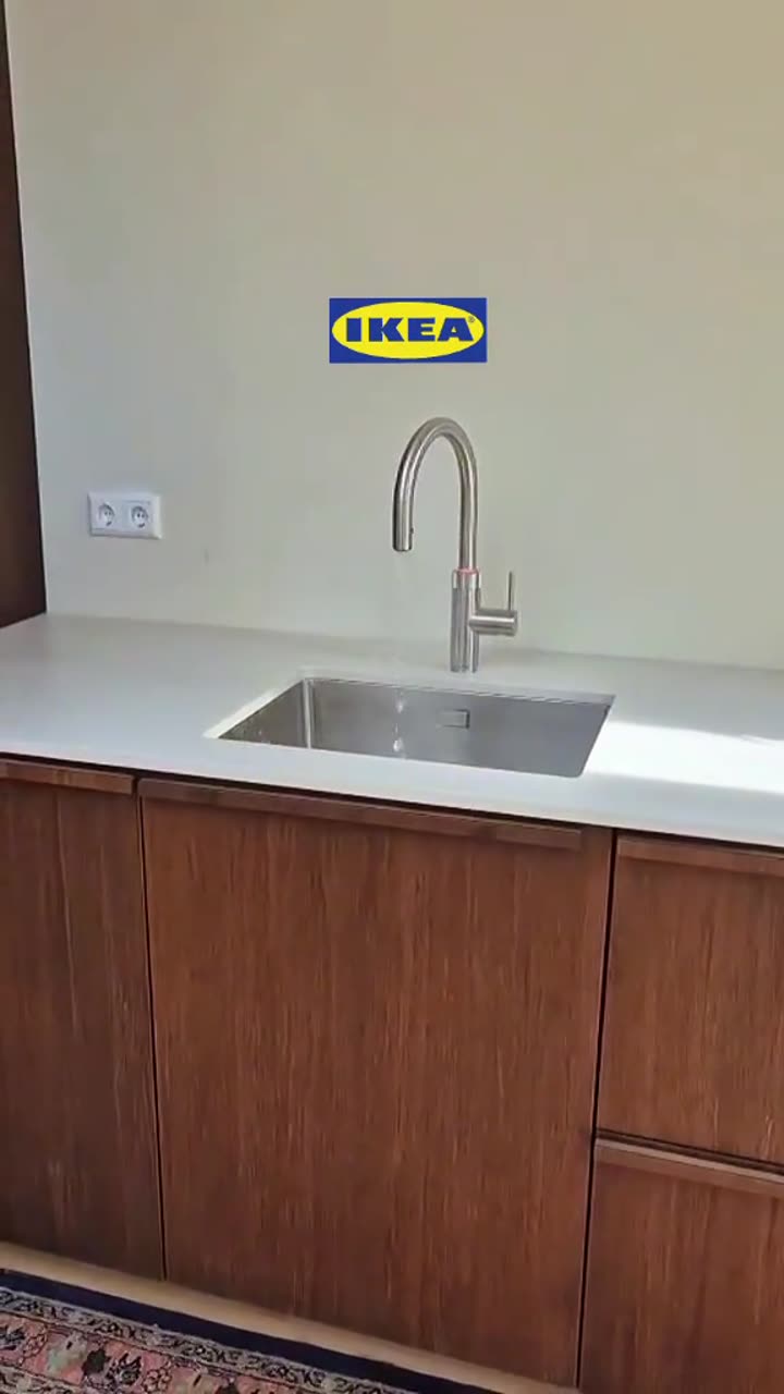 Keuken met donkere houten fronten op IKEA-kasten en een witte spoelbakwand, gemonteerd door Troncon Montage